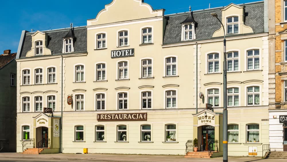 Kamienica Hotelu Sowa przy alei Grunwaldzkiej 49 w Elblągu. Na parterze szyld Restauracja i osobne wejście, wyżej szyld Hotel.